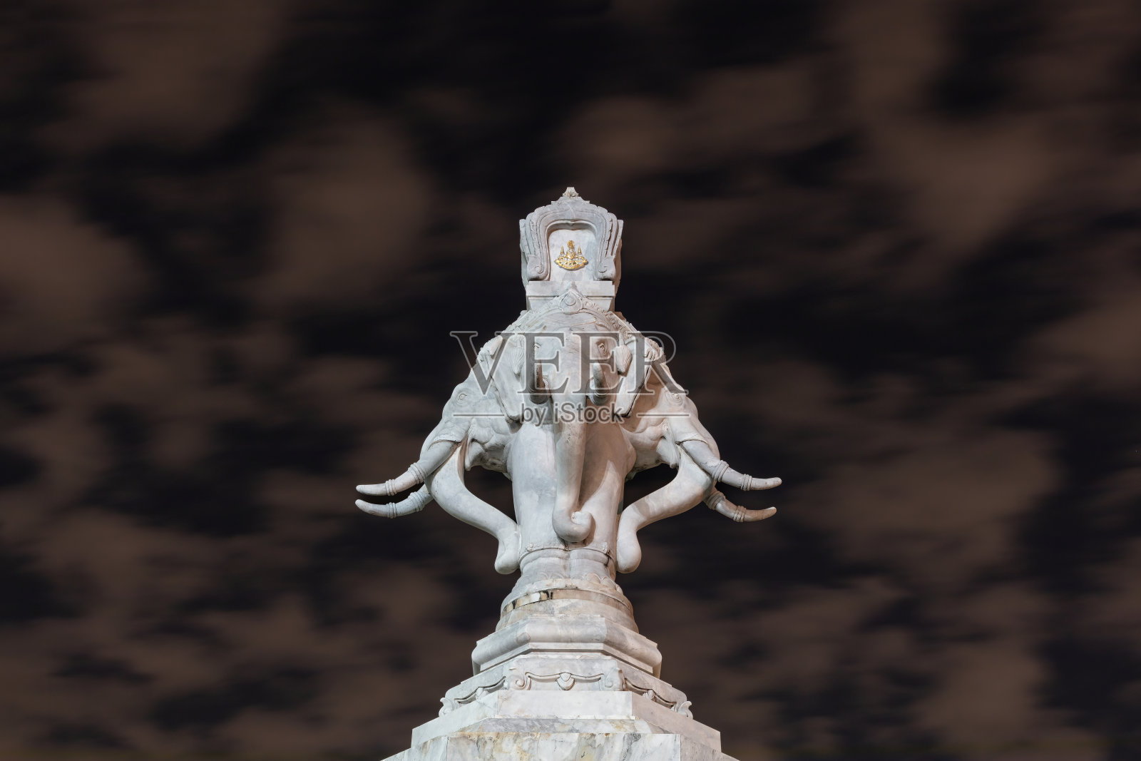 大理石象头雕像。背景是多云的夜空。照片摄影图片