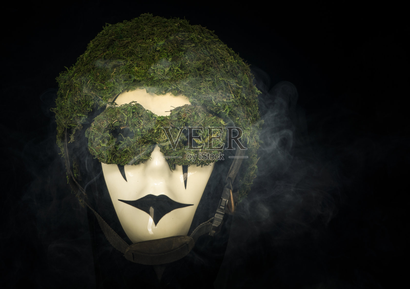 带着苔藓头盔和可怕面孔的吸烟面具照片摄影图片