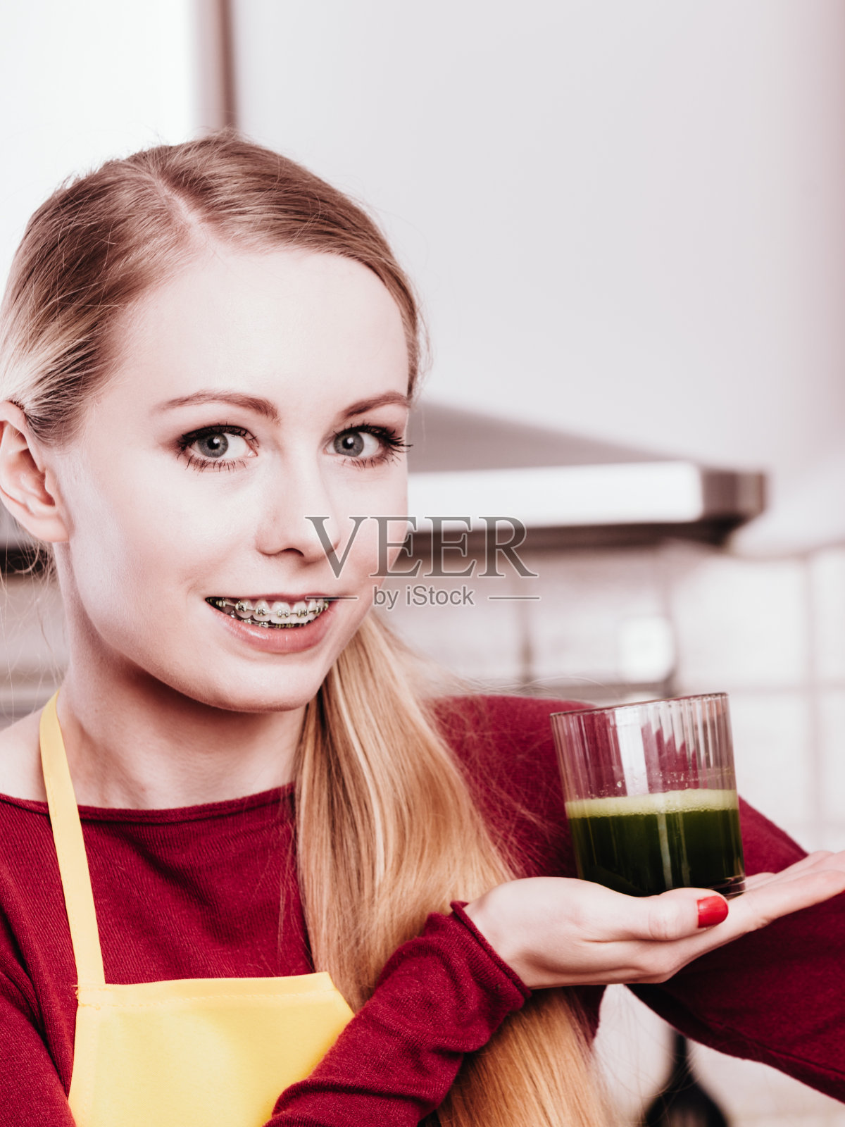 厨房里拿着蔬菜奶昔的女人照片摄影图片