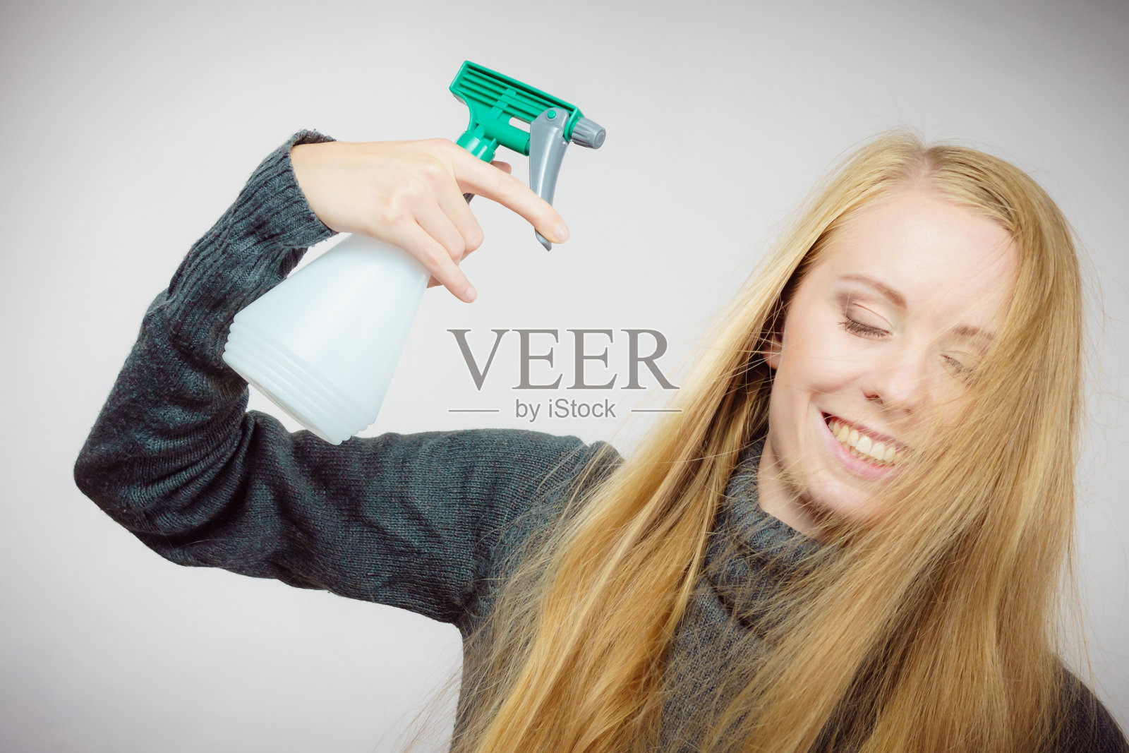 女性凌乱的长发拿着喷雾瓶照片摄影图片