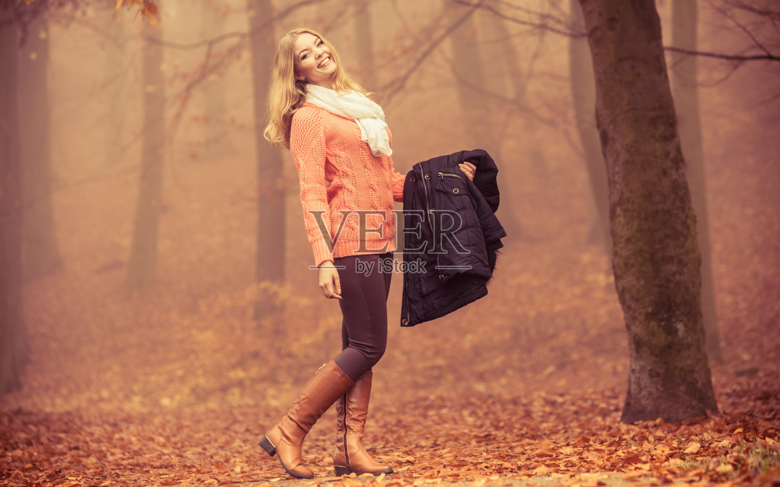 公园里穿着夹克微笑的时尚女人。照片摄影图片