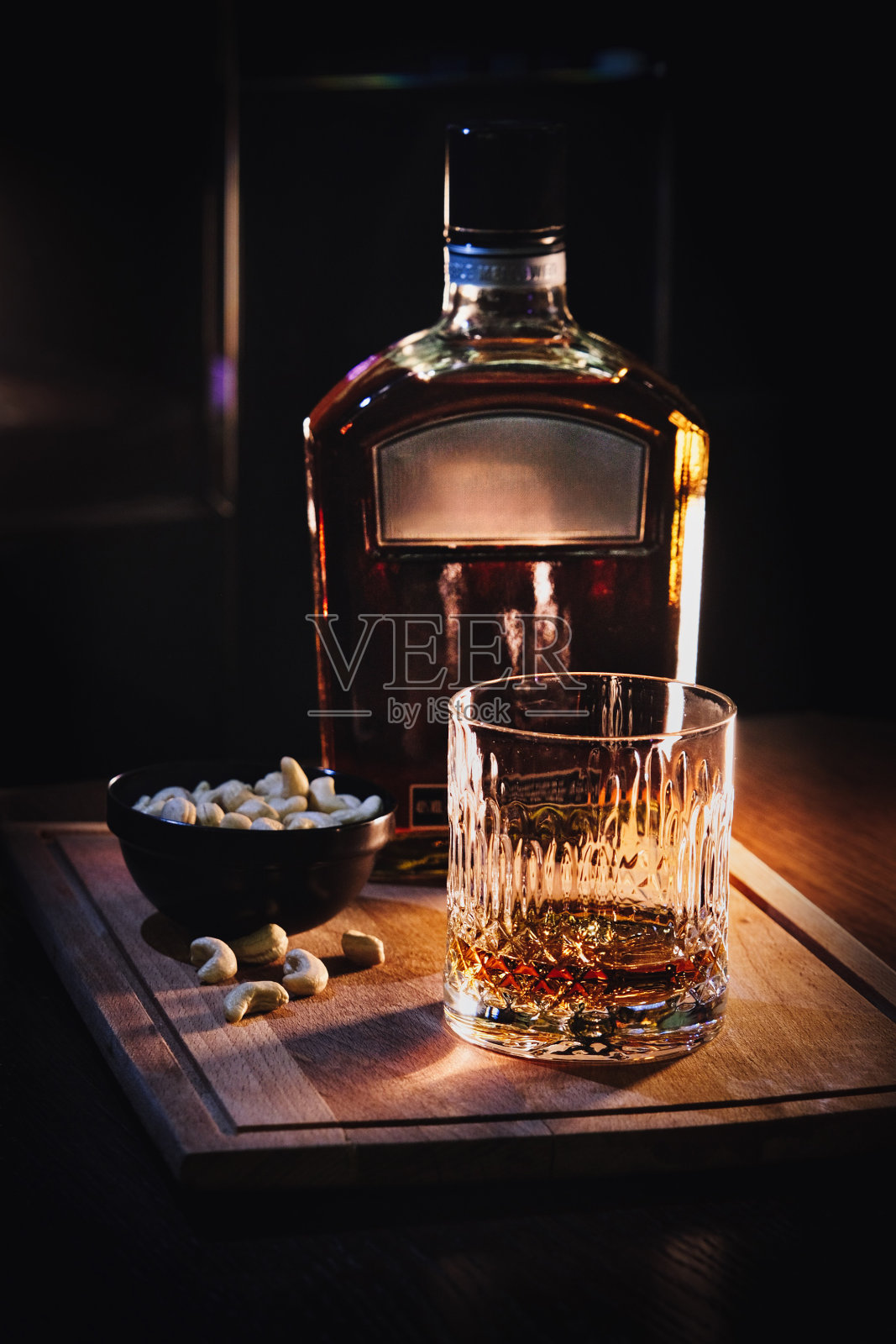在背光下用玻璃杯和瓶子装威士忌照片摄影图片