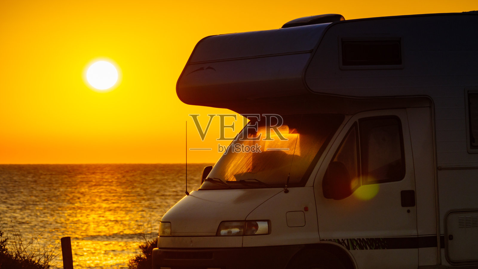 日出时沙滩上的露营车照片摄影图片