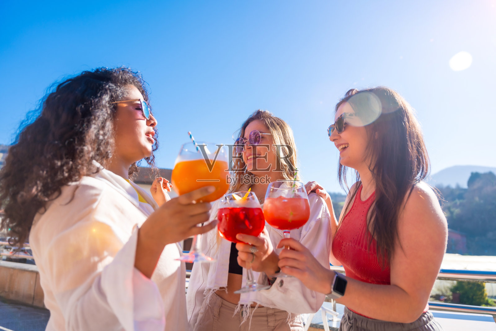 朋友们在露台上聊天，喝鸡尾酒照片摄影图片