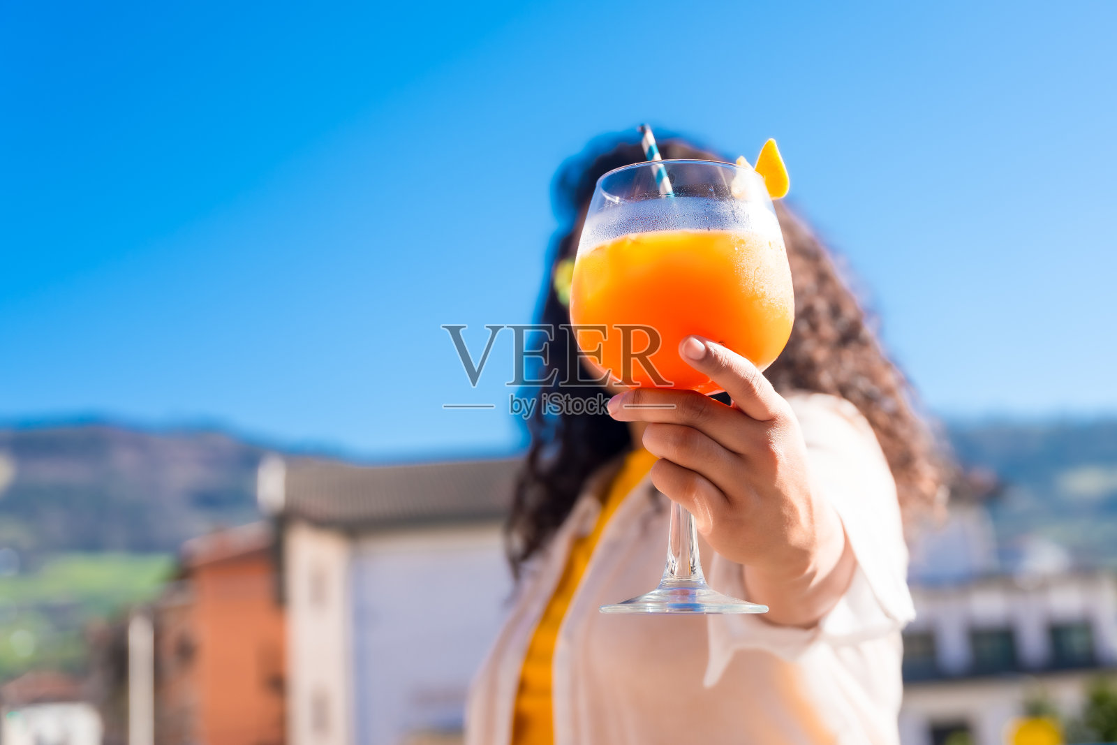 一个女人在屋顶展示并拿着鸡尾酒照片摄影图片