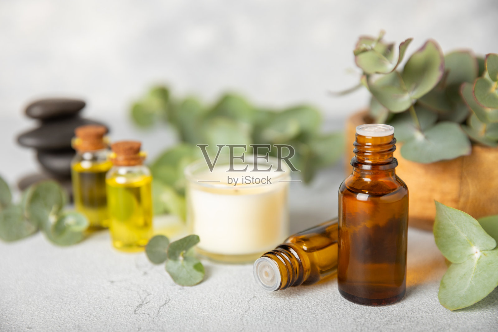 桉树精油在一个玻璃瓶子与绿色桉树叶子纹理木制背景。芳香疗法的概念。水疗中心。天然有机成分，用于化妆品和身体护理。本空间照片摄影图片