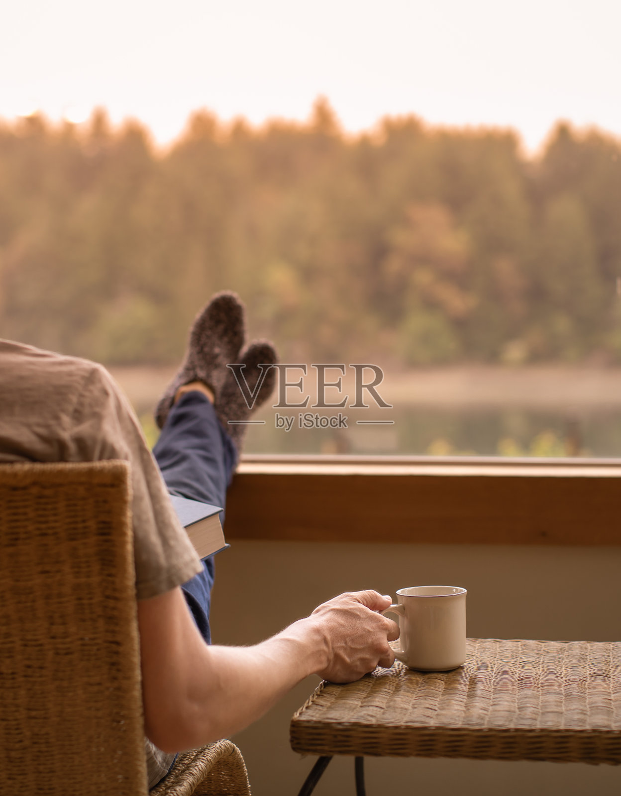 人们在家里放松，脚抬高，享受着咖啡和窗外美丽的晨景。照片摄影图片