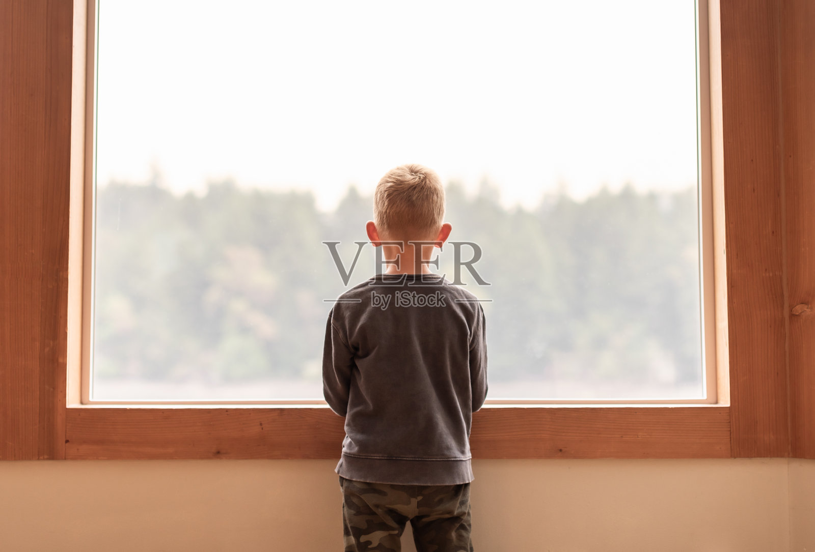 有思想的孩子在家里望着窗外。照片摄影图片