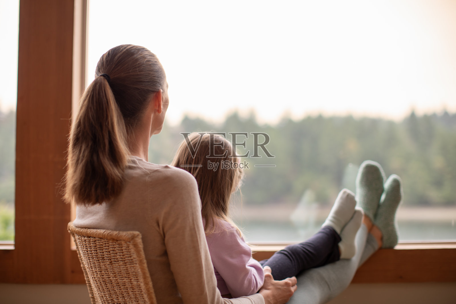 母女俩正欣赏着窗外的美景。照片摄影图片