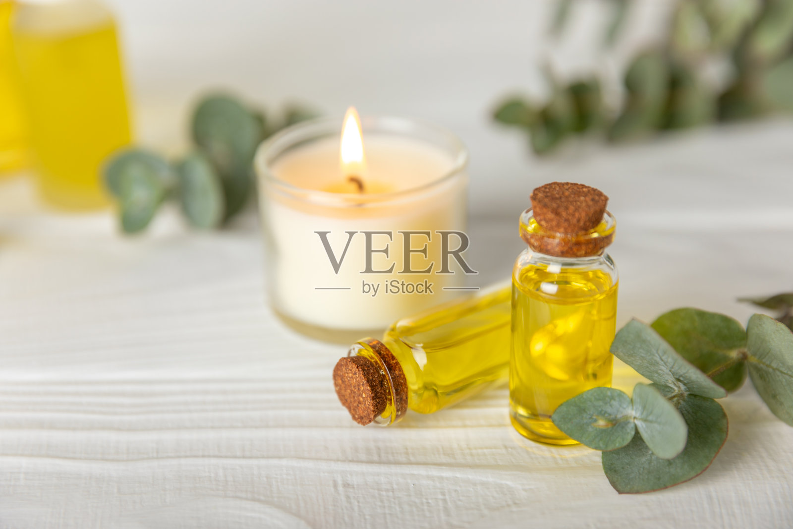 桉树精油在一个玻璃瓶子与绿色桉树叶子纹理木制背景。芳香疗法的概念。水疗中心。天然有机成分，用于化妆品和身体护理。本空间照片摄影图片