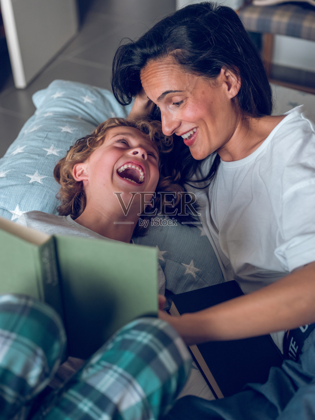 快乐的小儿子和妈妈在书里读有趣的故事照片摄影图片