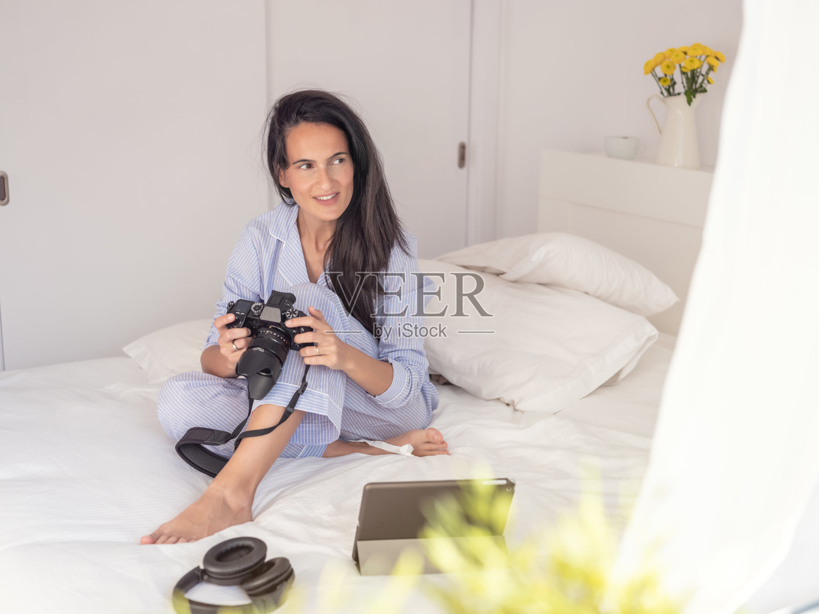 坐在床上拿着照相机的女士照片摄影图片
