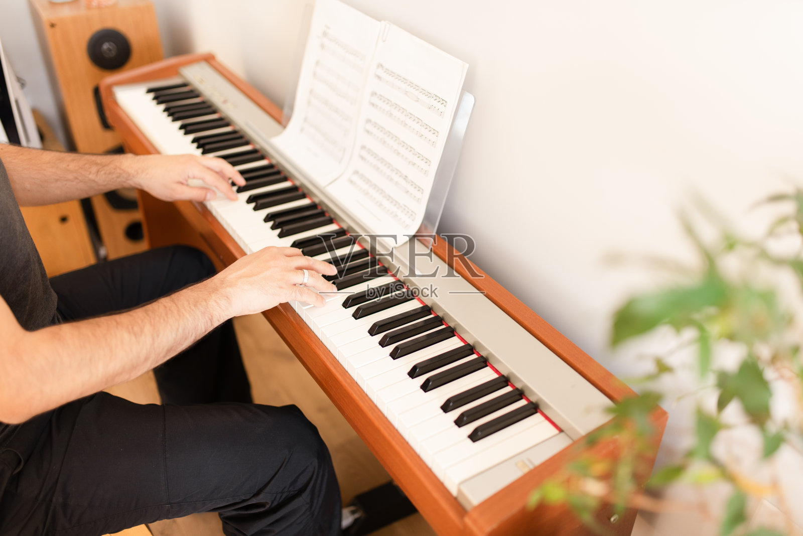 一个成年男子正在家里弹奏数码钢琴照片摄影图片