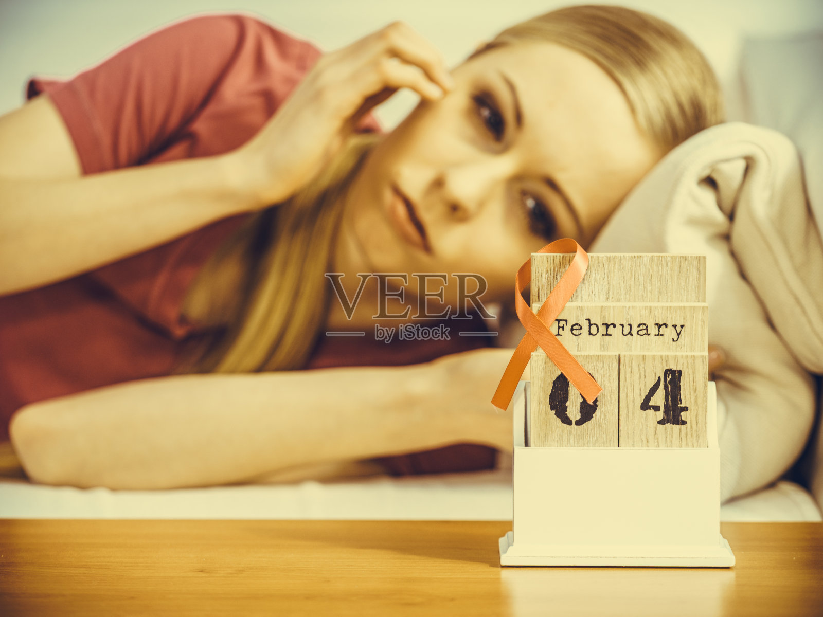 女人躺在床上，日历上的世界乳腺癌日照片摄影图片