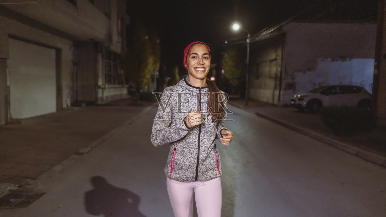 一个年轻的西班牙女子的肖像，在夜间在街上奔跑照片摄影图片
