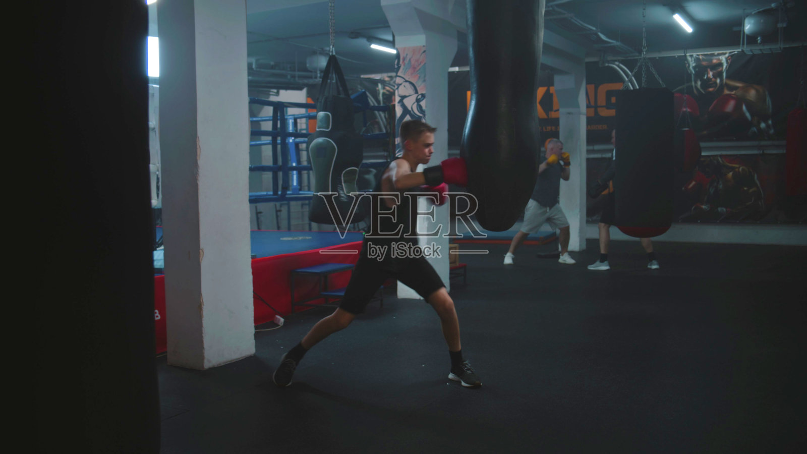 年轻的战士听从教练的指挥，击打沙袋照片摄影图片