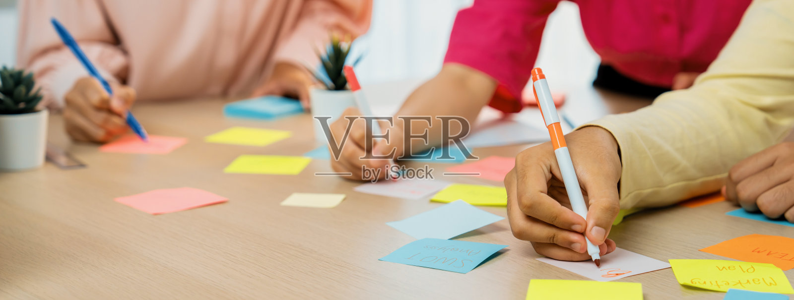 年轻的商业团体在彩色便利贴上集思广益。斑叶。照片摄影图片