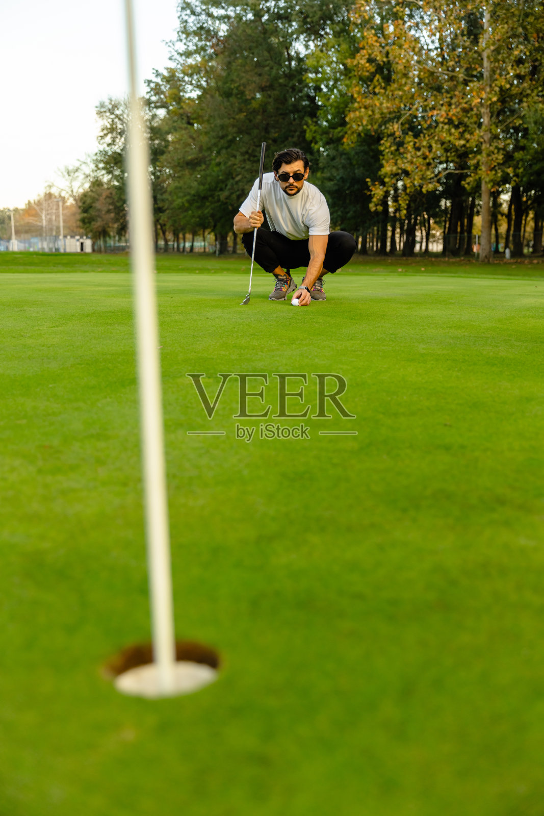 在高尔夫球场上的洞的特写，因为高尔夫球手打了球-股票照片照片摄影图片