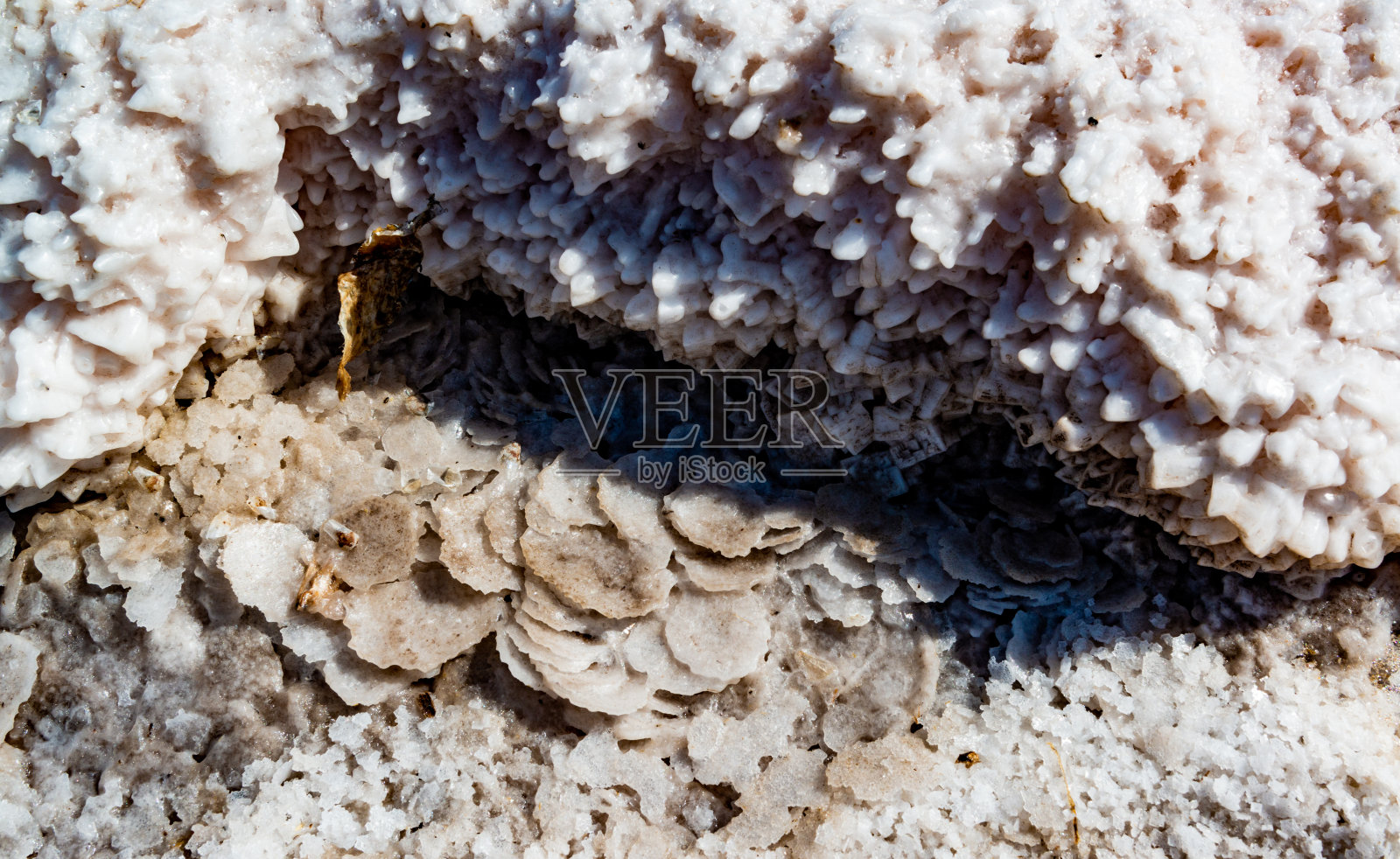 盐湖。岸边岩石上自沉的氯化钠盐。超咸水照片摄影图片