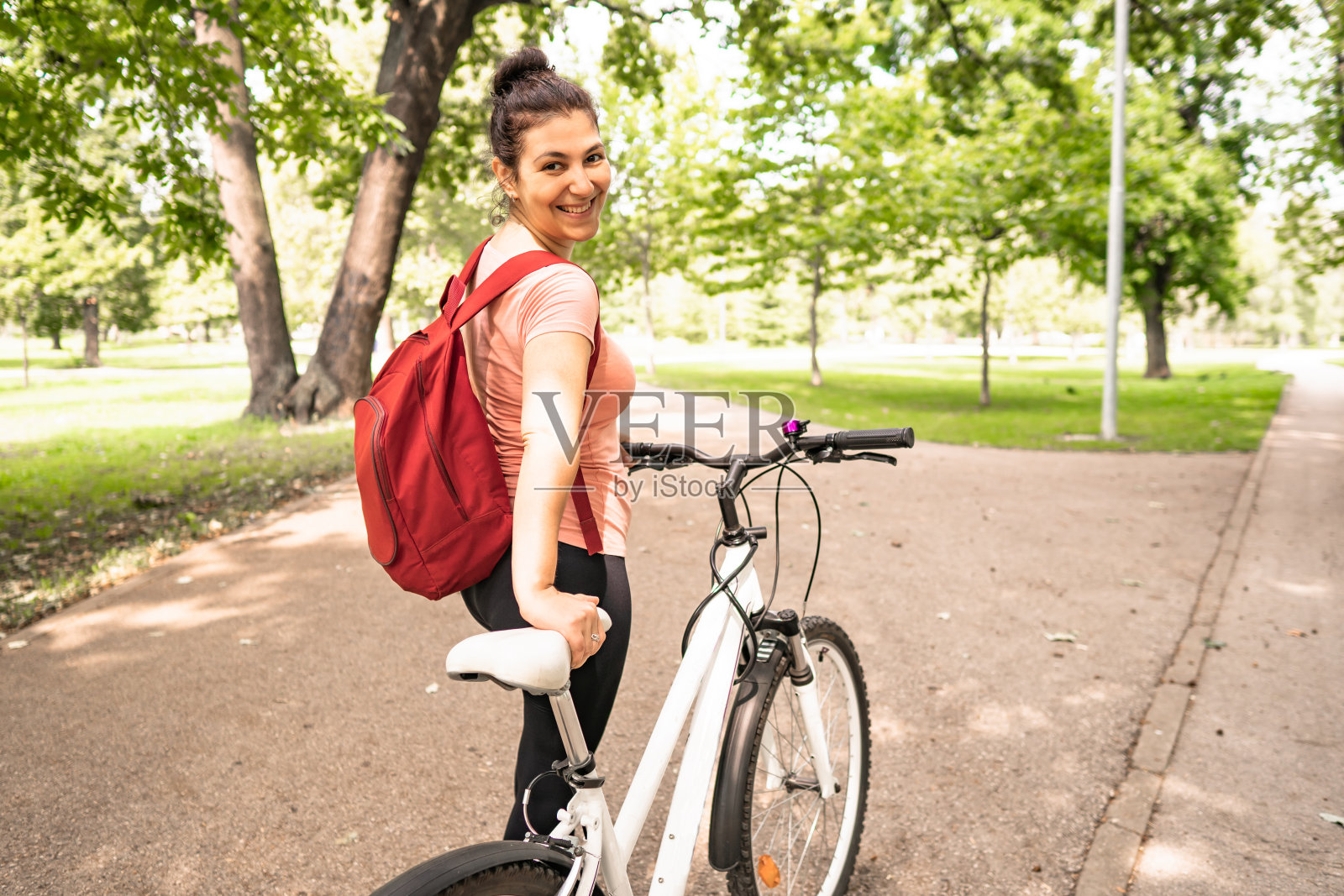 一个年轻的微笑的女人骑着自行车享受大自然的肖像照片摄影图片