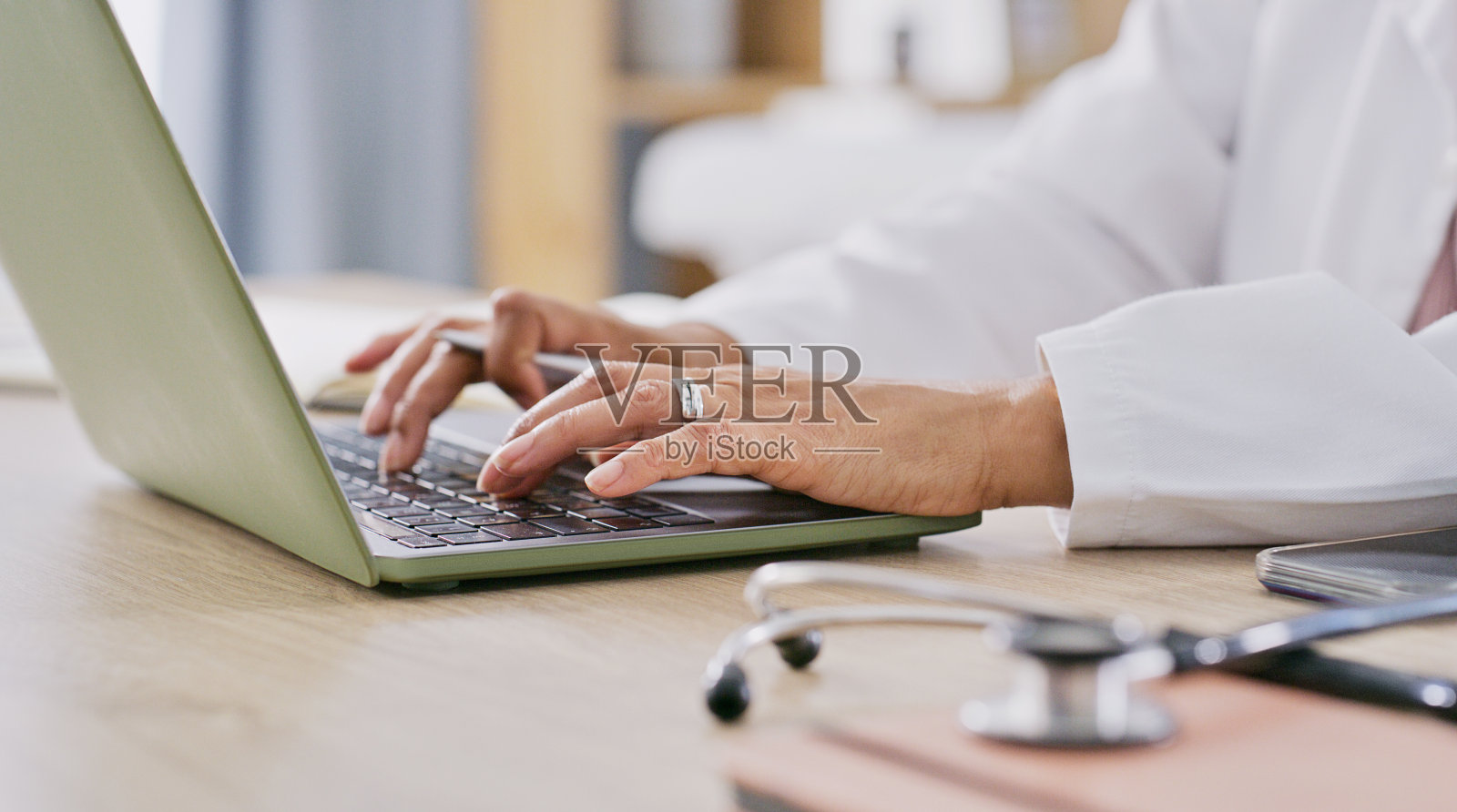 医生，打字和手在笔记本电脑上进行研究，沟通或虚拟咨询。医学，听诊器和外科医生的电脑特写与专家信息，报告病人和反馈照片摄影图片