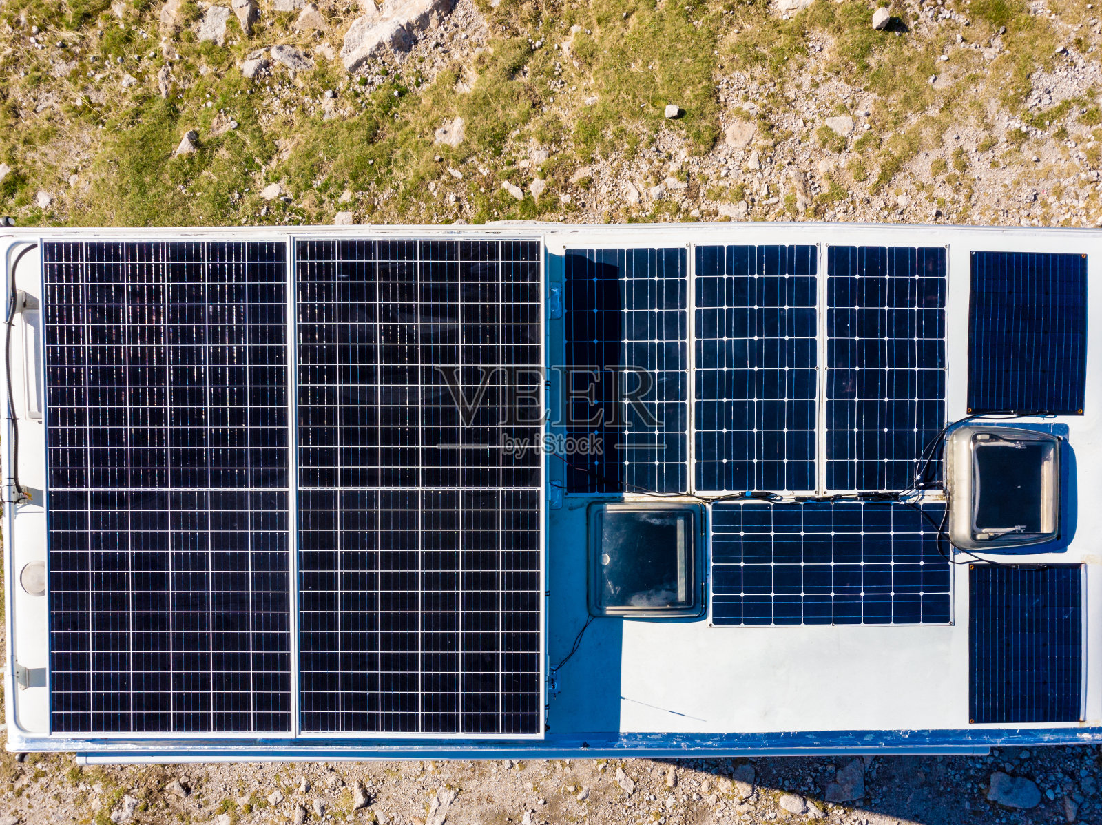 在屋顶上安装太阳能板的房车在大自然中露营。鸟瞰图照片摄影图片
