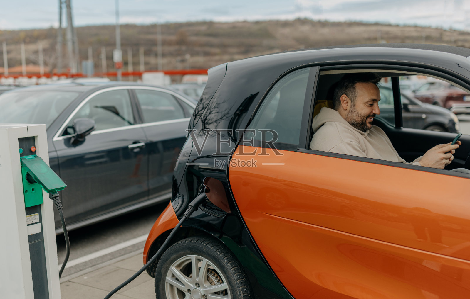 中年男子在汽车充电时使用手机照片摄影图片
