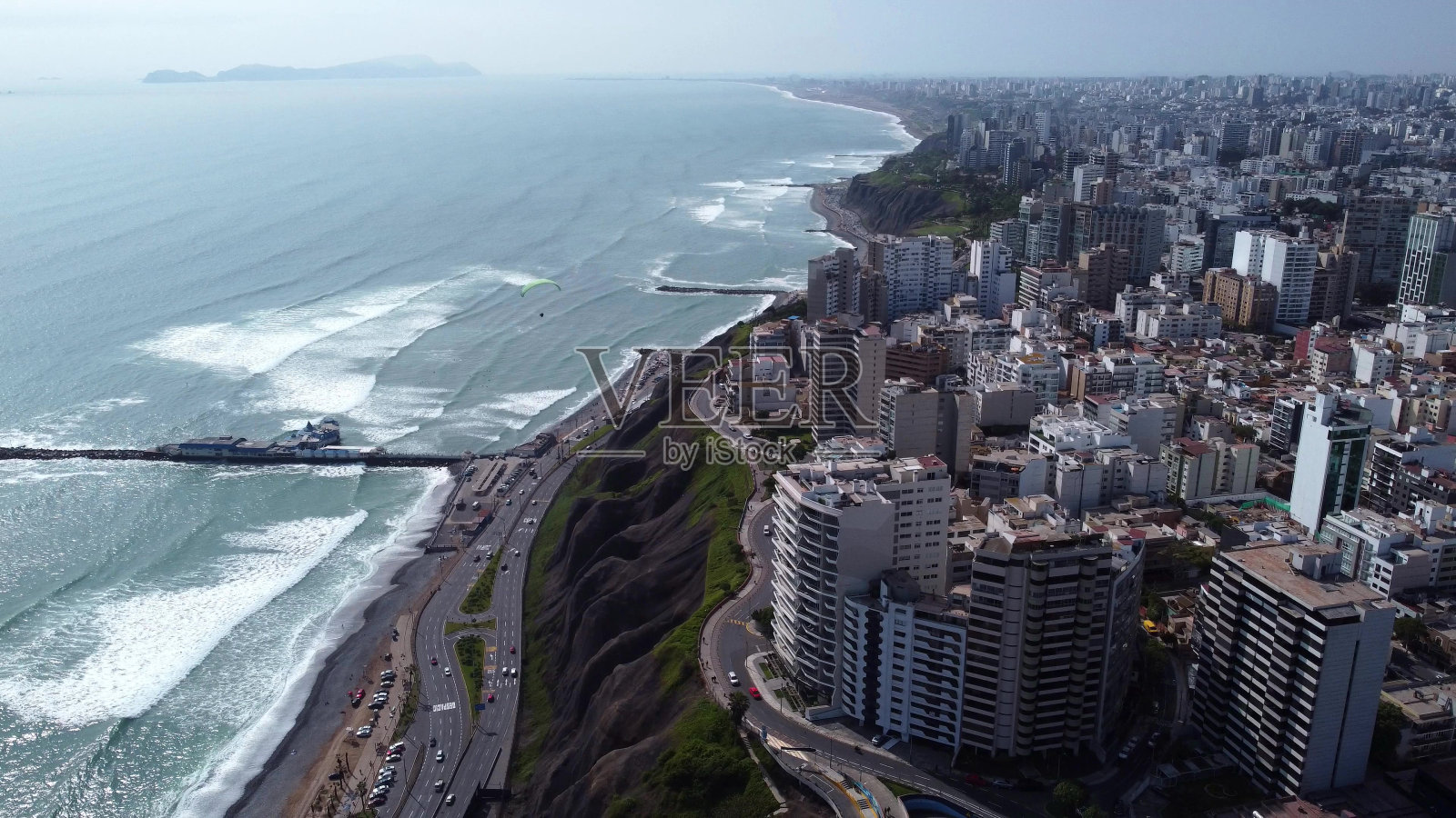 在秘鲁米拉弗洛雷斯，我们可以看到佛得角的太平洋，还有一些人在练习滑翔伞。照片摄影图片