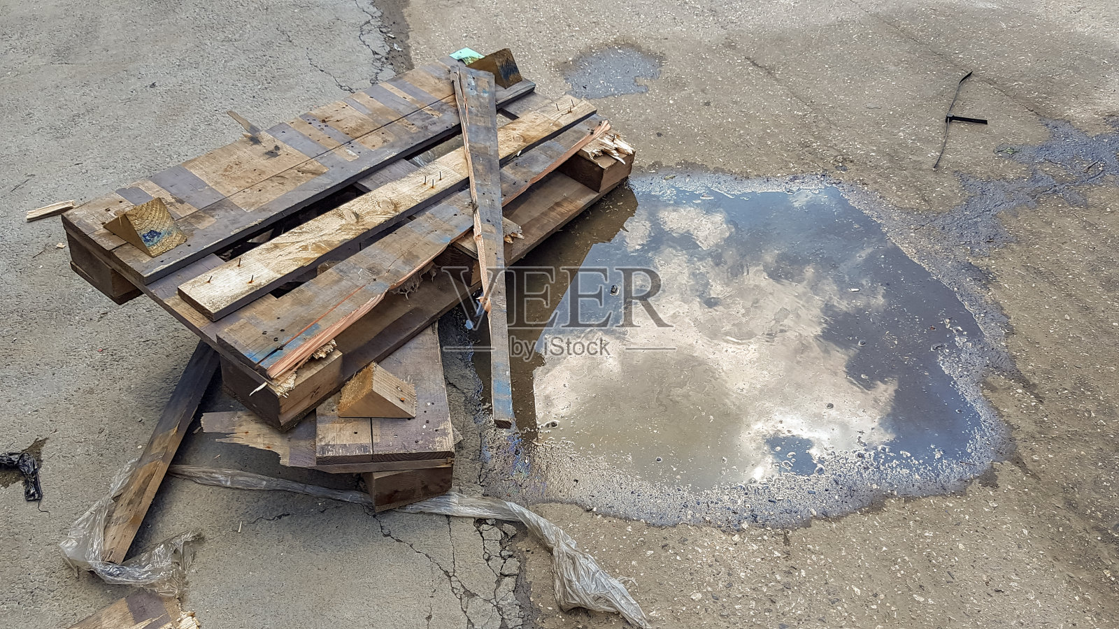 在水坑附近的地上留下的一块木头照片摄影图片