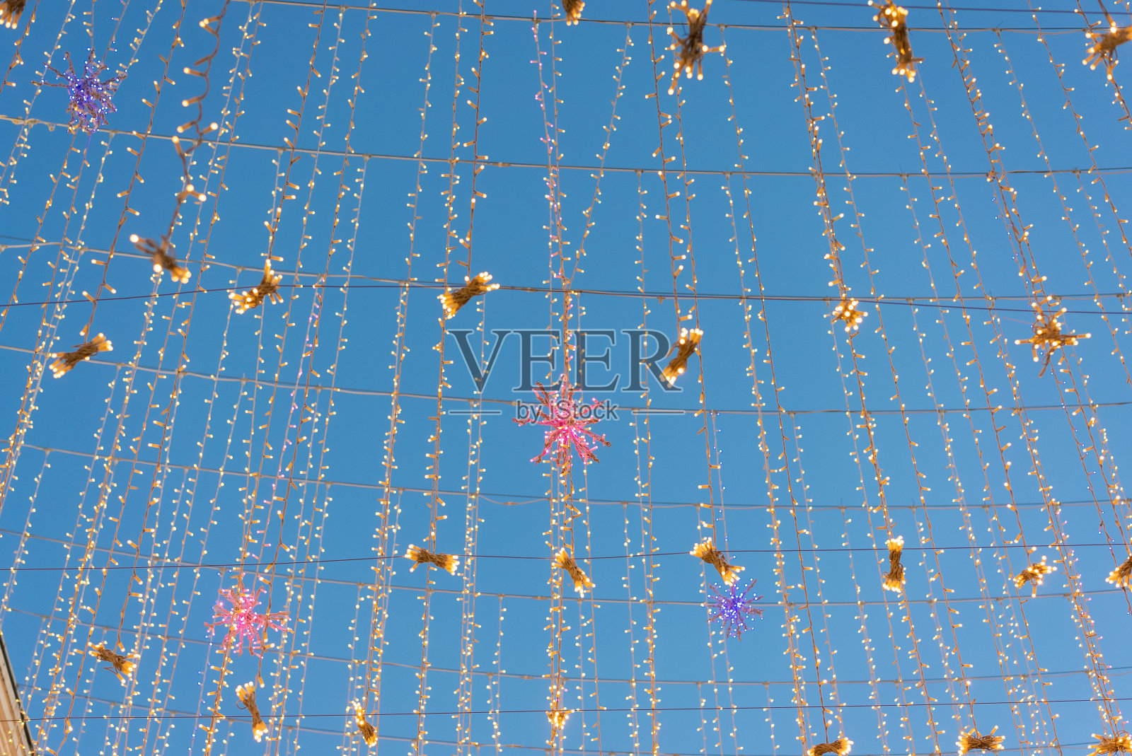 圣诞的光串映衬着深蓝色的天空照片摄影图片