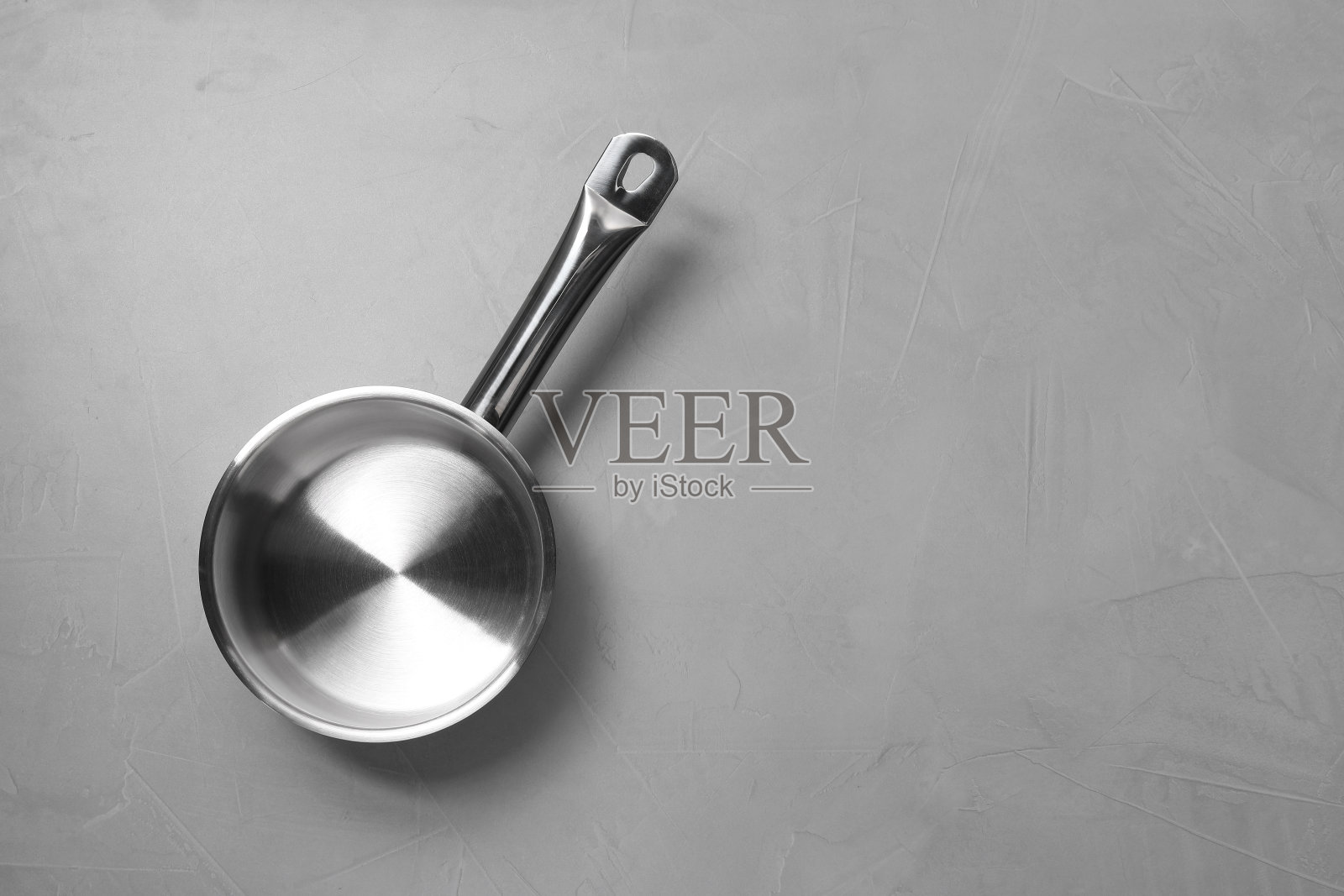 空的钢锅放在浅灰色的有纹理的桌子上，俯视图。文本空间照片摄影图片