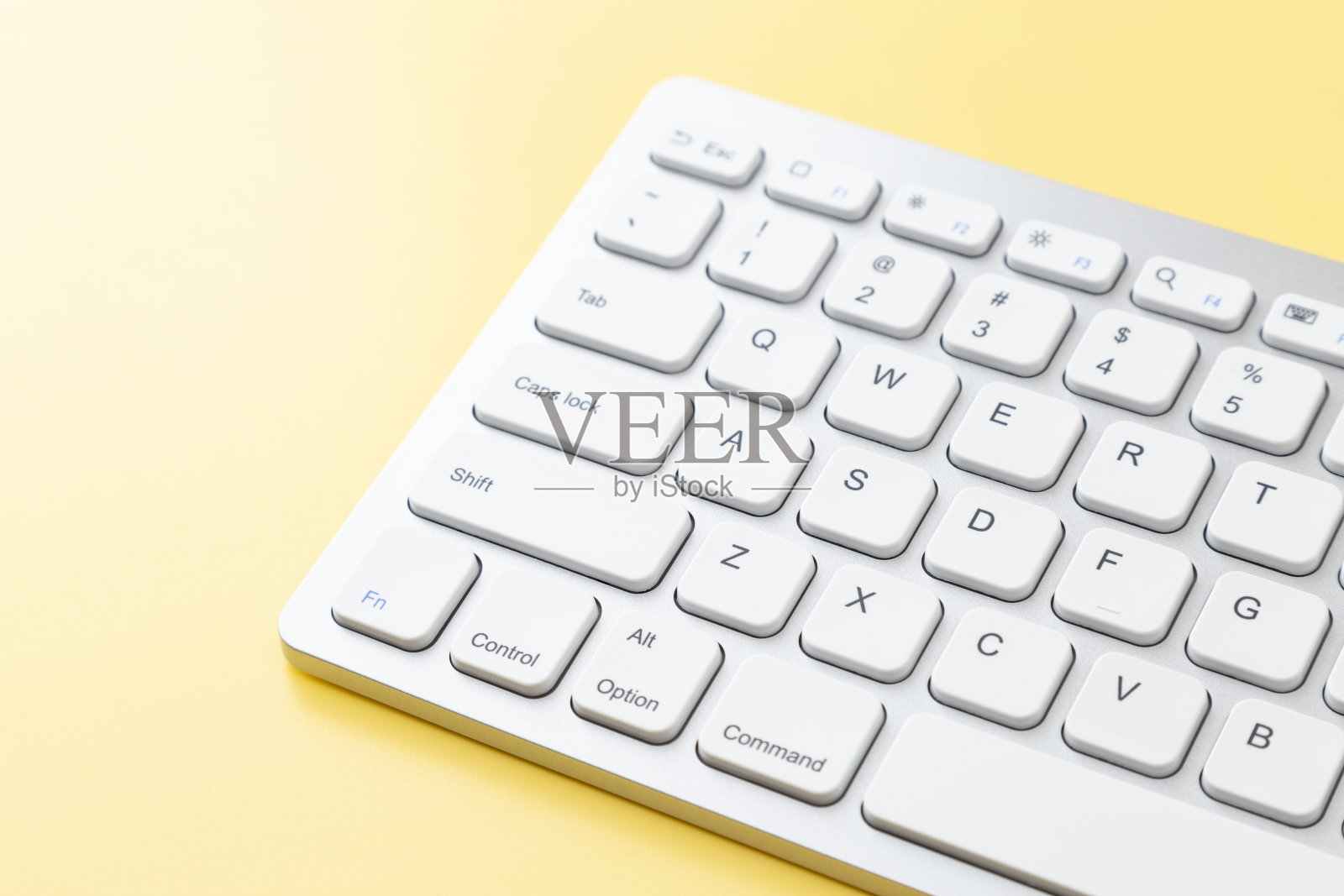 键盘在黄色背景上。照片摄影图片