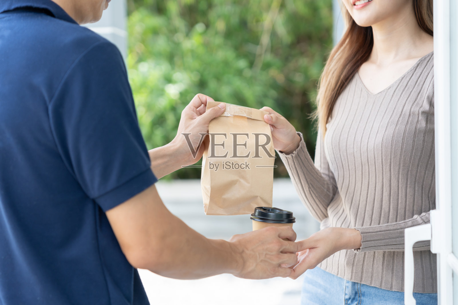 快乐微笑的亚洲妇女从快递员前屋收到纸袋包裹的食物。快递员送快递。网购、纸盒、外卖、邮差、快递服务、包裹照片摄影图片