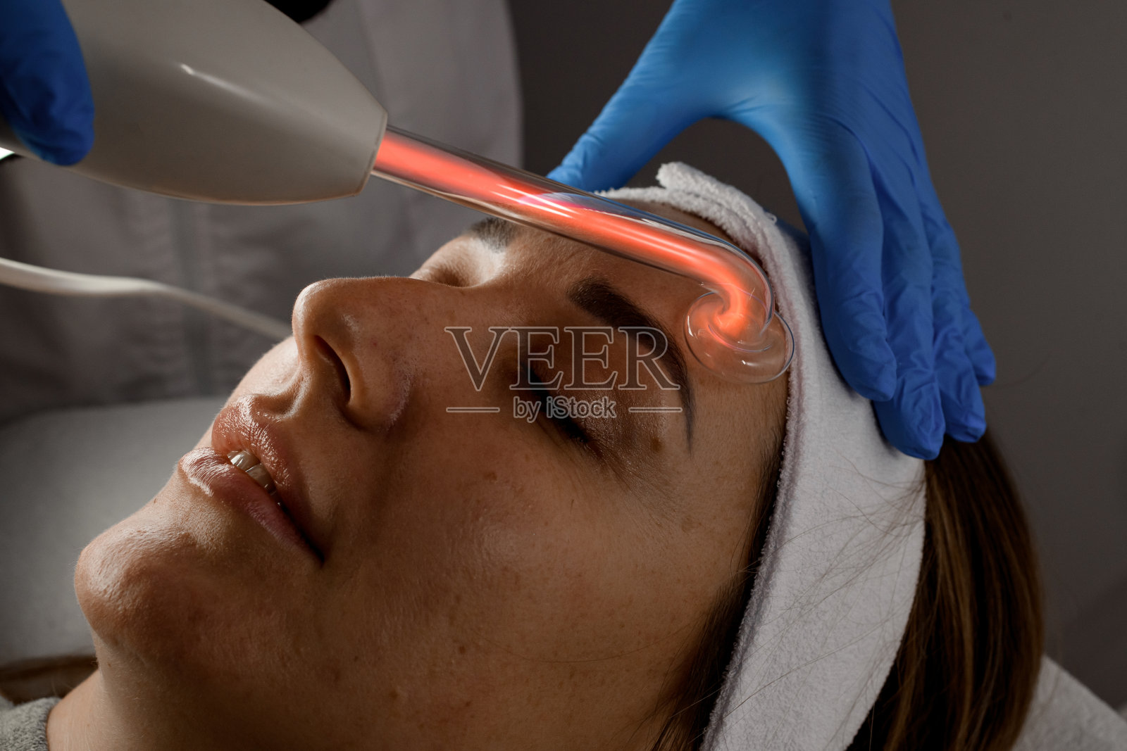 美容师在美容院为一名妇女进行人格化手术(特写)照片摄影图片