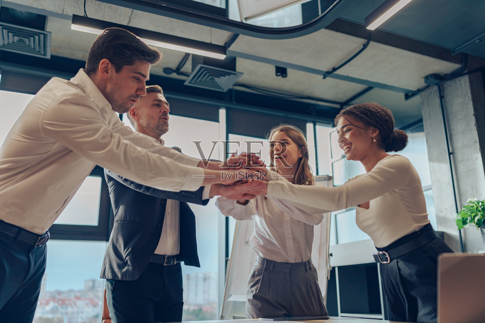 在办公室完成项目后，一群商人手拉手。高质量照片照片摄影图片