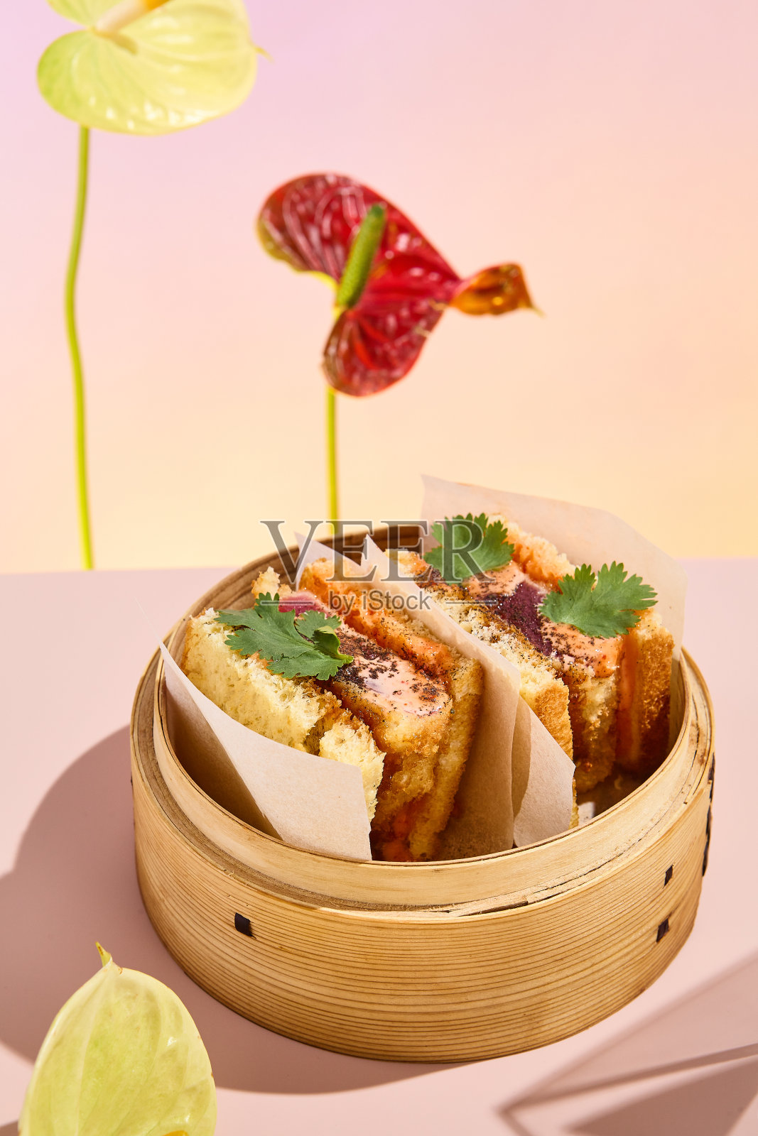 亚洲三明治与金枪鱼和辣酱，呈现在竹制蒸笼与抽象的花卉艺术照片摄影图片