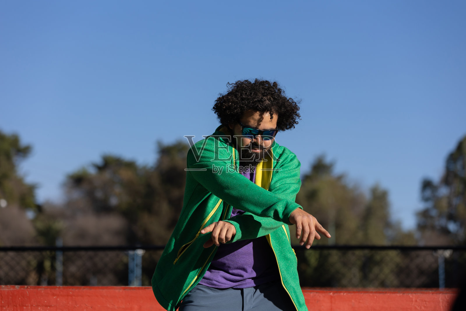 年轻的墨西哥卷发男子，在墨西哥的一个公园里快乐地跳舞，幸福和自由的概念照片摄影图片