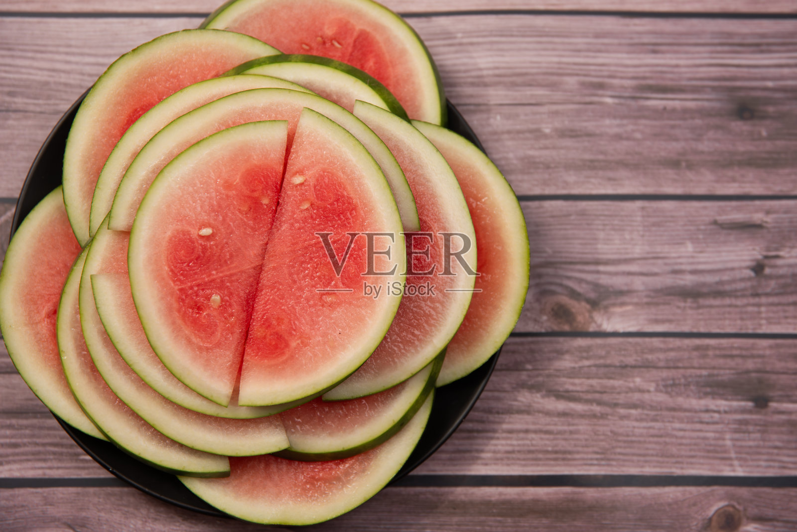 木质背景上的西瓜片特写照片摄影图片