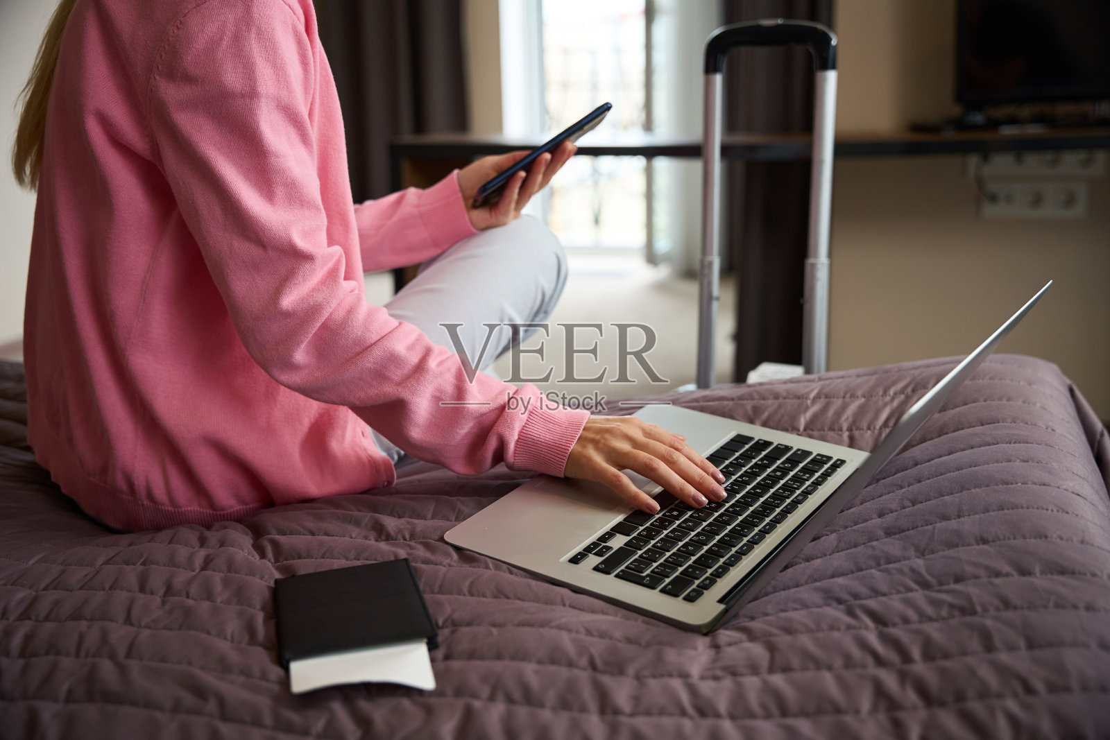 女人正在旅馆房间里摆弄手提电脑照片摄影图片