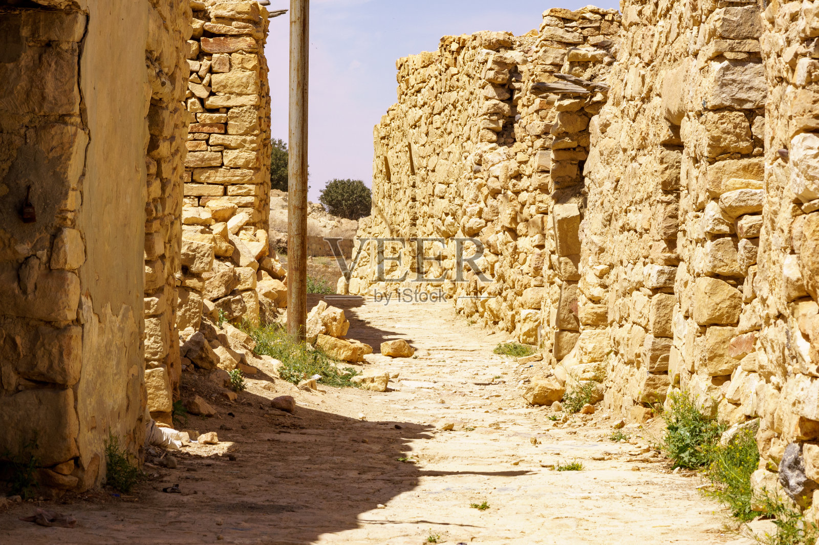 约旦达纳生物圈保护区风景如画的传统奥斯曼村庄。狭窄街道两旁破旧不堪的老房子和栅栏。照片摄影图片