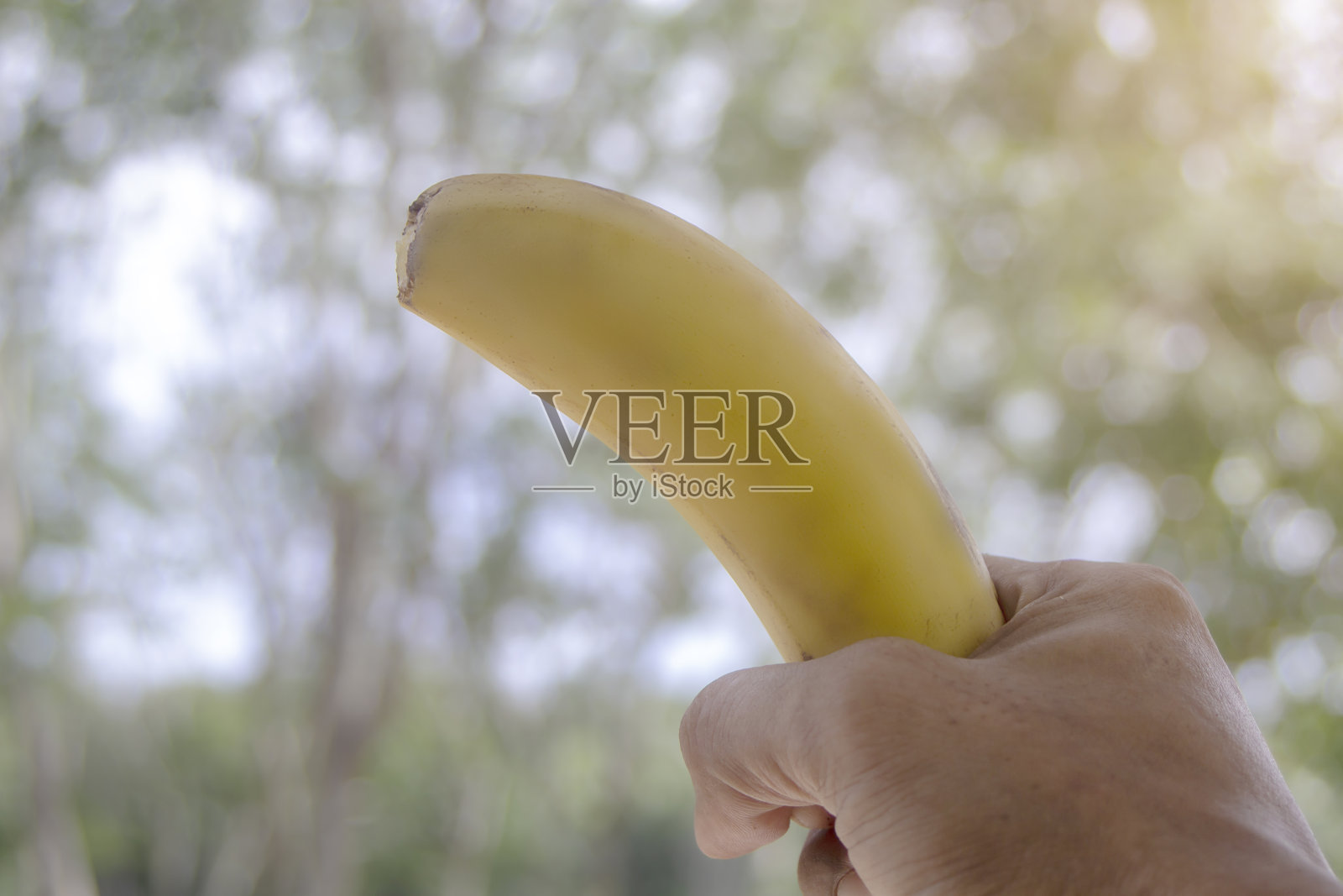 手里拿着香蕉，水果上带着迷离照片摄影图片