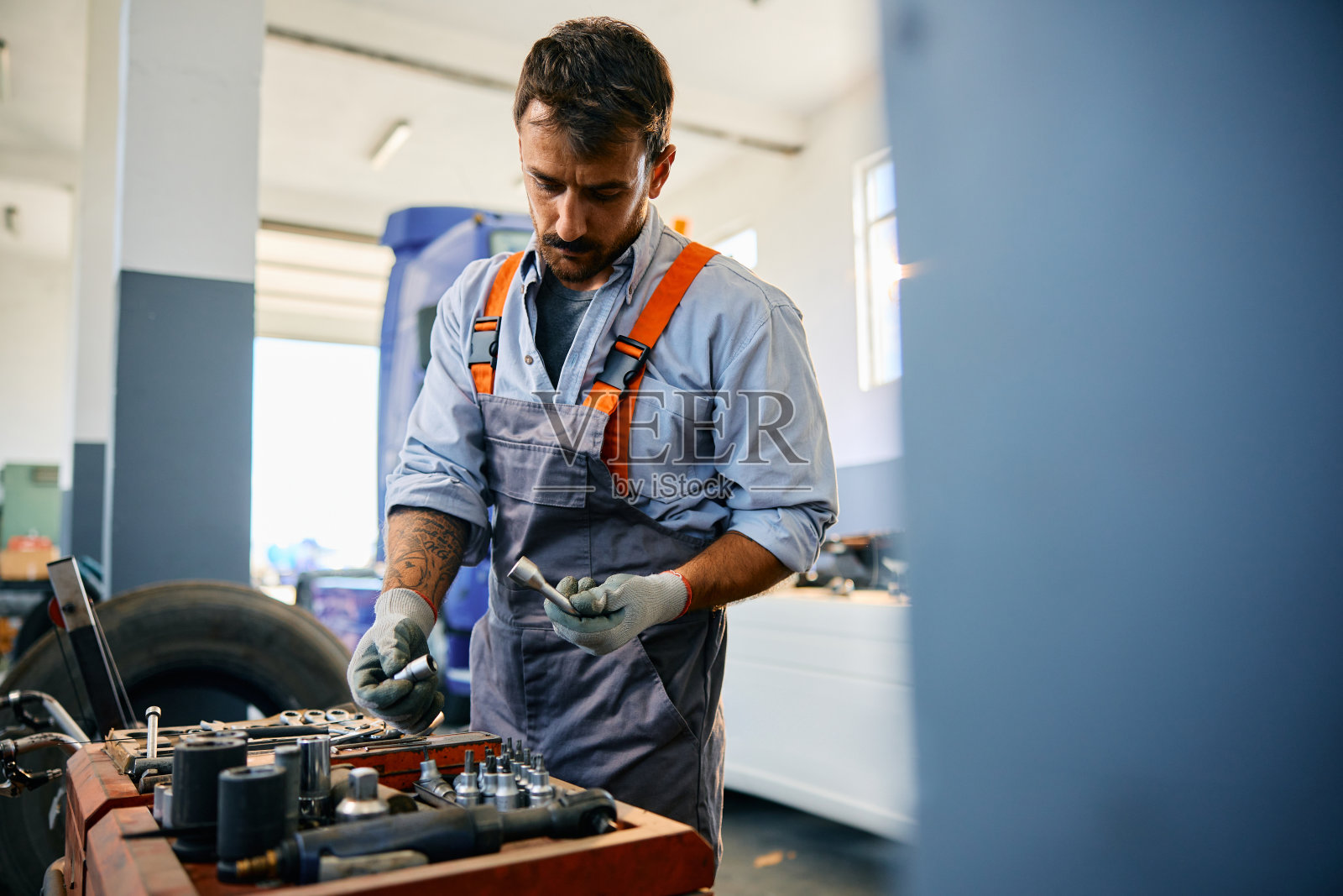 在卡车修理厂工作的中年成人机械师;照片摄影图片