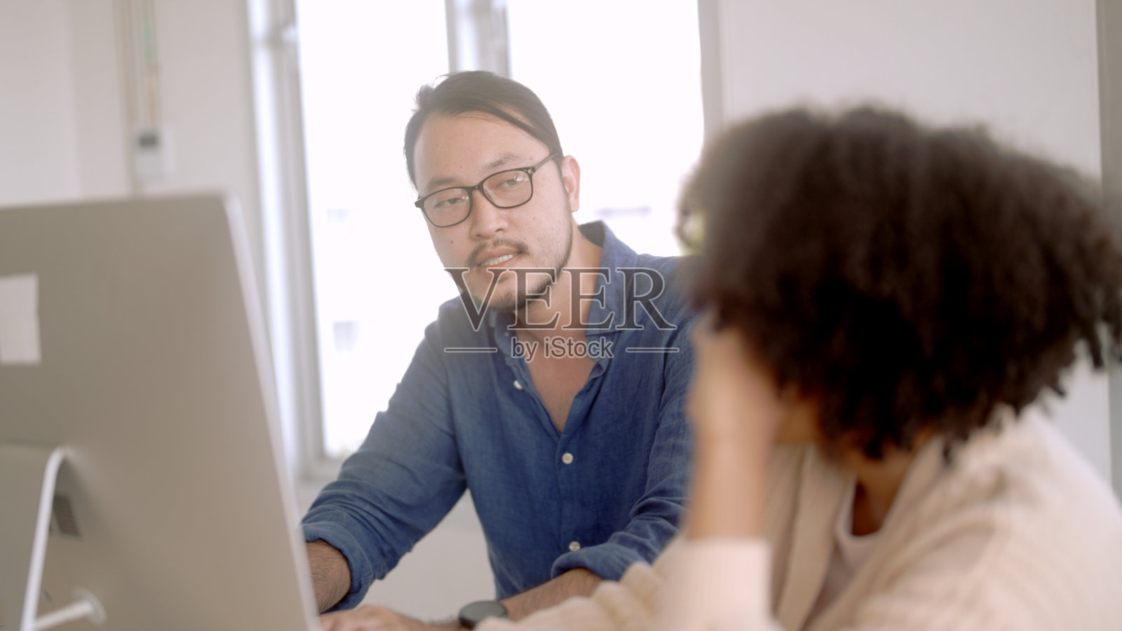 同事们正在教晚辈工作。照片摄影图片