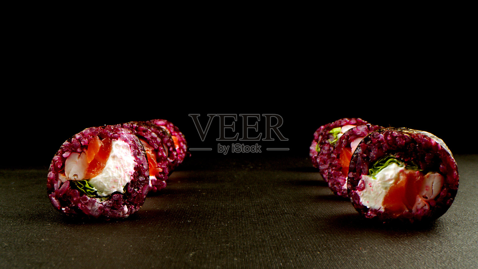 各种类型的寿司与红鱼子酱，鱼，费城奶酪特写。一套黑色背景的美味日本寿司卷。宣传健康美味海鲜食品的理念。照片摄影图片