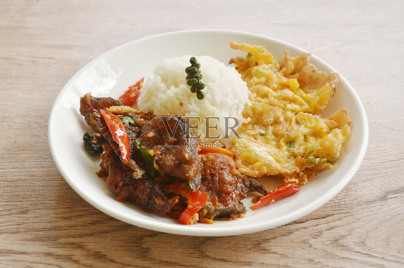 辣炒脆脆鲶鱼咖喱罗勒叶米饭和泰式鸡蛋蛋卷照片摄影图片