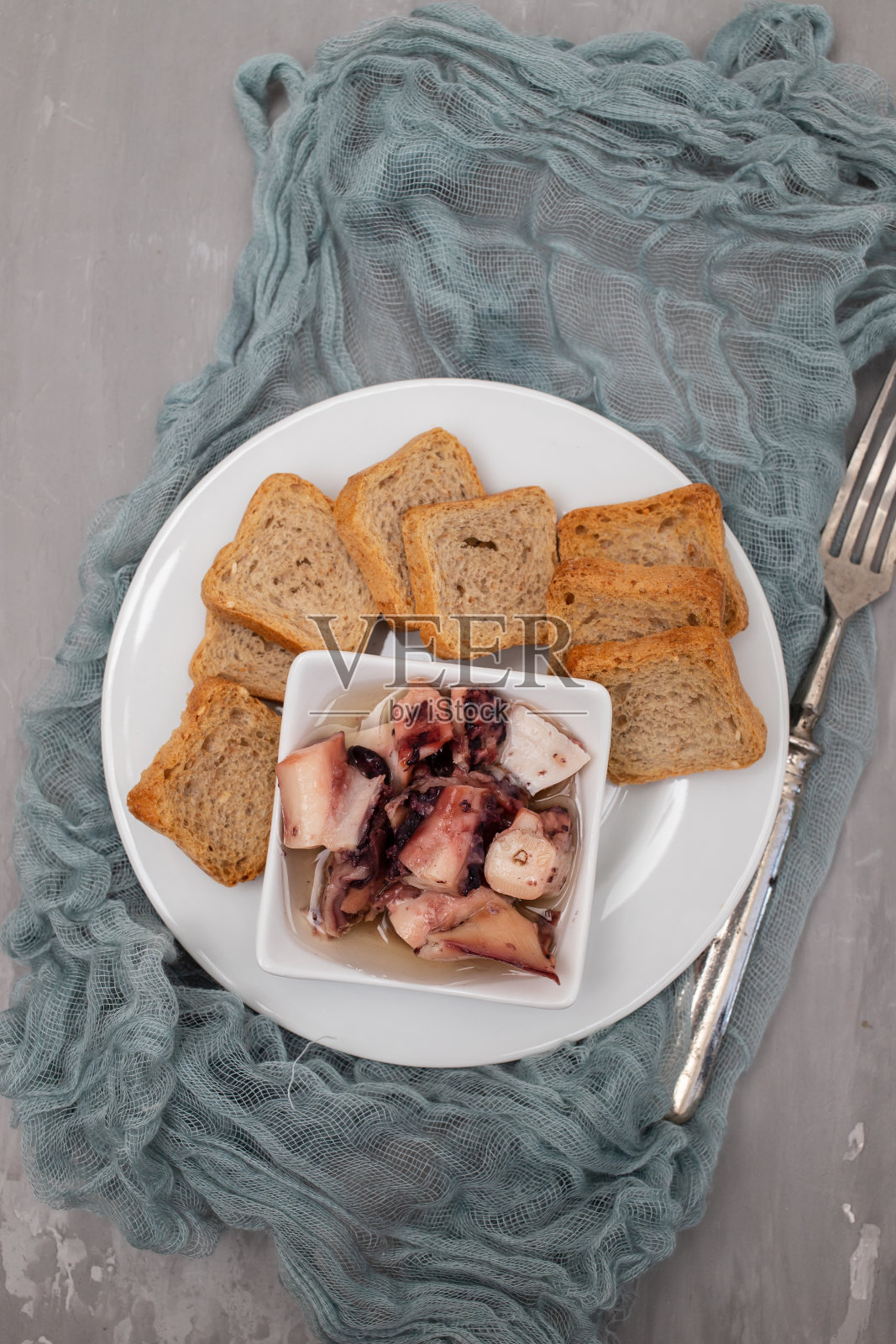 小碗油章鱼沙拉和烤面包照片摄影图片