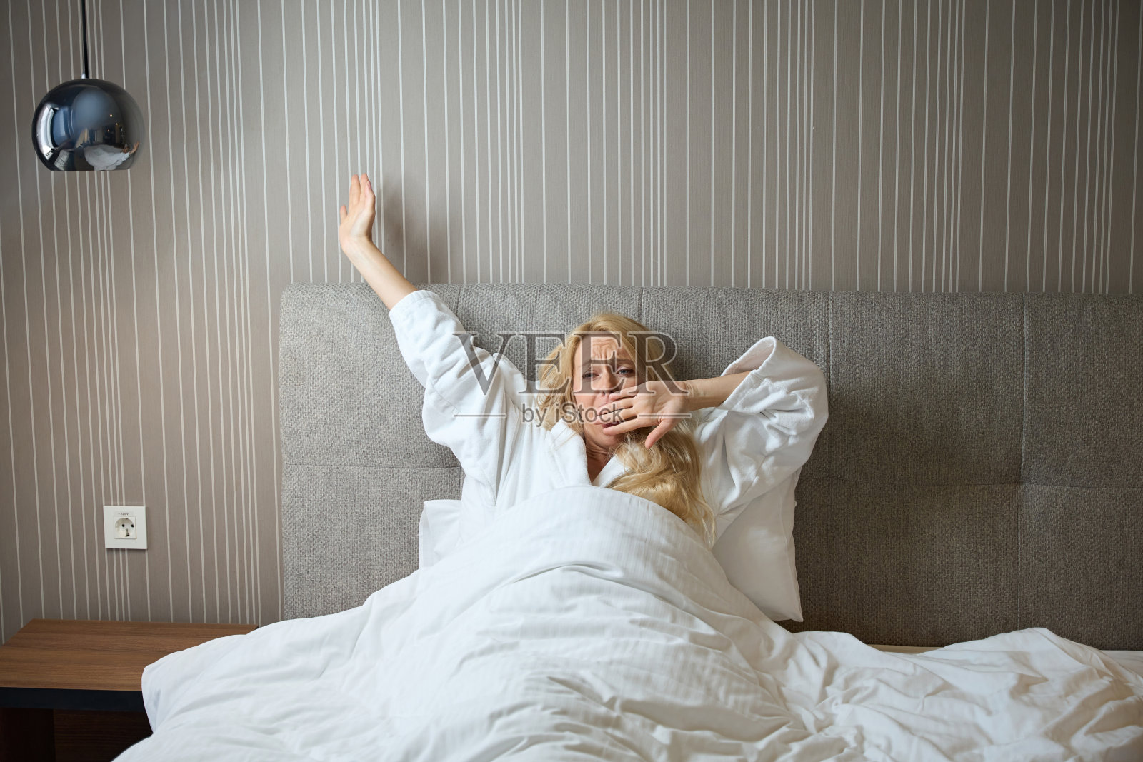 昏昏欲睡的女人从卧室里醒来照片摄影图片