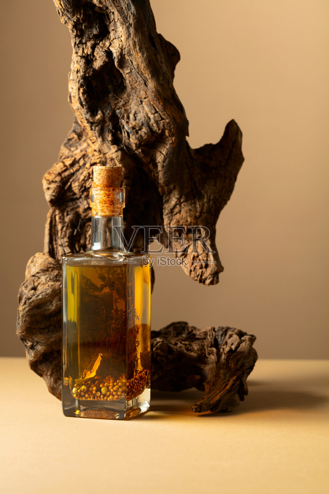 一瓶辛辣的橄榄油和橄榄树在米色的背景。照片摄影图片