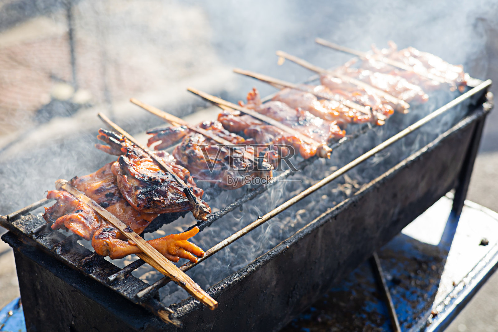 鸡是在炭火上烤的。这是街头小吃。照片摄影图片