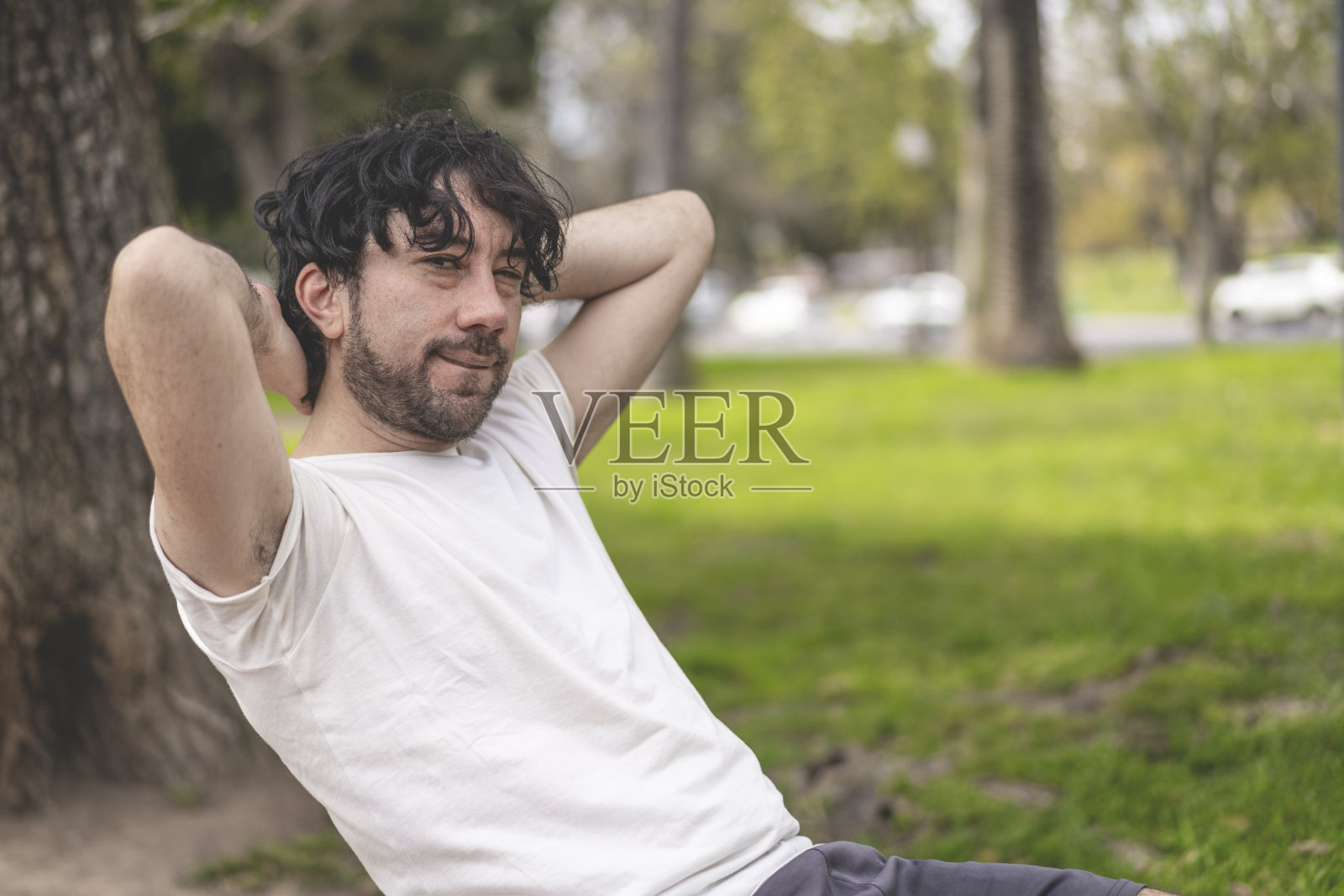 英俊迷人成熟大胡子拉丁男子40多岁在公园做仰卧起坐的肖像照片摄影图片